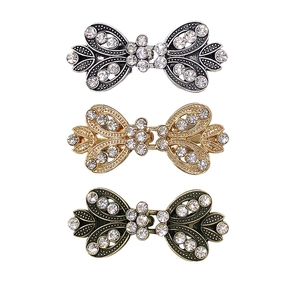 Bow tie rhinestone sweater clips in silver gold and bronze metal finish on white background