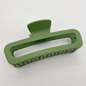 Close-up of green matte square claw clip showing hollow rectangular design and inner teeth
