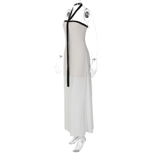 Détail de robe longue blanche dos nu avec bordures contrastées noires et nœuds élégants