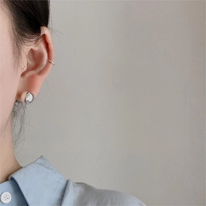 Close-up of minimalist S925 sterling silver bean stud and ear cuff on a model's ear