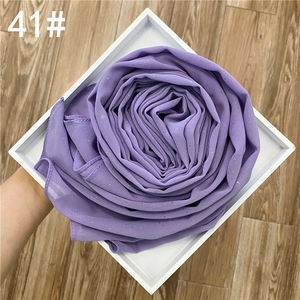 Détail du hijab en mousseline violette avec paillettes dorées et ourlet roulé délicat