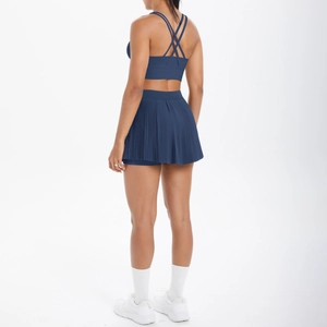 Détail d'un ensemble brassière de sport à dos croisé et jupe plissée bleu marine