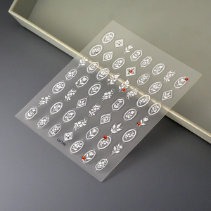 Makroaufnahme der weißen 3D-Präge-Blumen-Nagelsticker Co-149 mit roten Strasssteinen