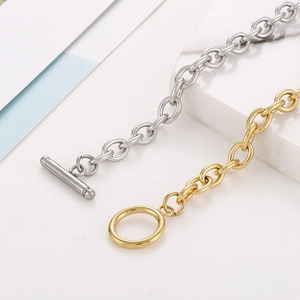 Close-up of gold and silver stainless steel O-chain necklaces with classic OT toggle clasps