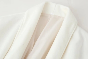 Close-up of elegant white wool coat collar with refined stitching and smooth lining