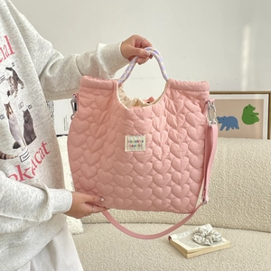 Detail van roze gewatteerde shopper met hartjespatroon en paarse gevlochten handvatten