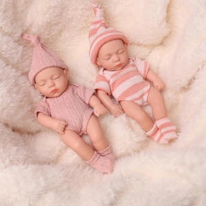 Realistic 8-inch newborn baby dolls in pink and striped outfits sleeping on white fur