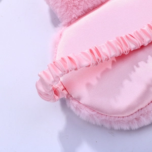 Detailed back view of pink plush sleep mask showing silky lining and elastic strap