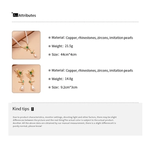Detail view of pearl necklace with gold butterfly pendant featuring green and yellow zircons