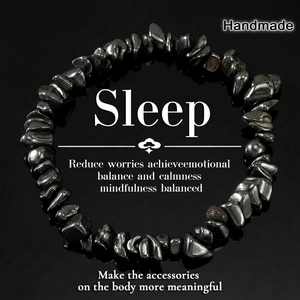 Handmade irregular black hematite stone bracelet with glossy finish on reflective surface