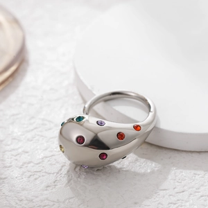 Close-up of a silver ring with a spherical head set with vibrant multi-colored gemstones