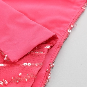 Detailed view of hand-sewn sequins and pearls on bright pink sequined evening gown fabric