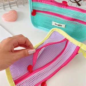 Close-up of double-layer mesh makeup bag with colorful zippers and metal ring pullers