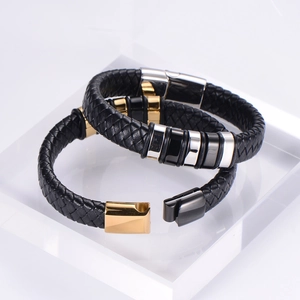 Detail of woven black leather bracelets with gold and gun black magnetic metal clasps