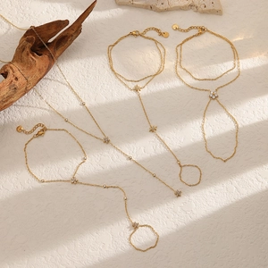 Elegant gold flower zircon finger chain bracelet with artistic shadows on beige texture