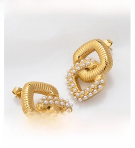 Detail of interlocking gold hoop earrings featuring textured rings and white pearl accents