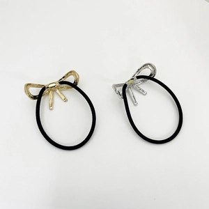 Detailansicht elastischer Haargummis mit goldenen und silbernen Metallschleifen