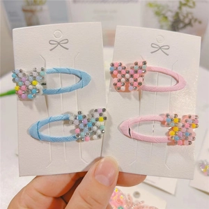 Detailed view of pink and blue ribbon hair clips decorated with sparkling crystal butterflies