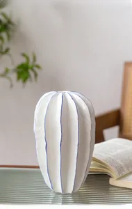 Primer plano de un jarrón de cerámica blanca tipo cactus con líneas azules finas