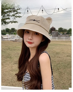 Detailed view of beige bucket hat with 3D cat ears and whiskers embroidery on canvas fabric