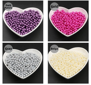 Macro detail of colorful 3-10mm ABS pearls in heart-shaped bowls for DIY crafts