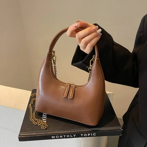 Close-up of brown PU leather tote bag with stylish metal chain and double zipper closure