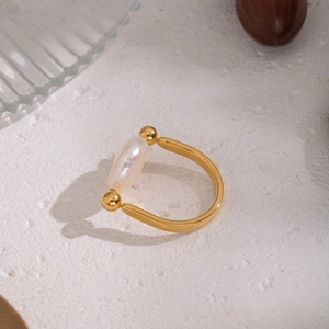Detailed view of an irregular baroque pearl set on a polished gold U-shaped ring