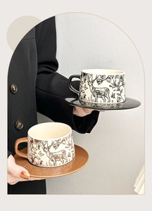 Detail of vintage ceramic coffee cup and saucer sets with elegant deer and floral patterns