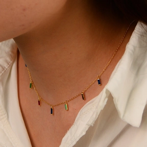 Detail of gold chain necklace with colorful square zircon charms worn on neck