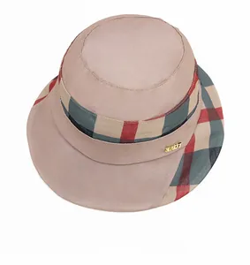 Detail of elegant pink bucket hat featuring plaid ribbon and a metal LOVE pendant charm