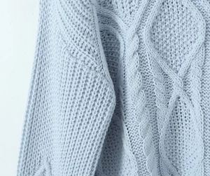 Detailed close-up showing the cable knit pattern and texture of this light blue sweater