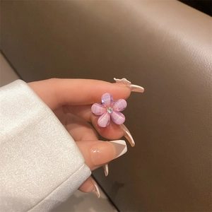 Detail of small flower hair clip with pink gradient petals and a sparkling center diamond