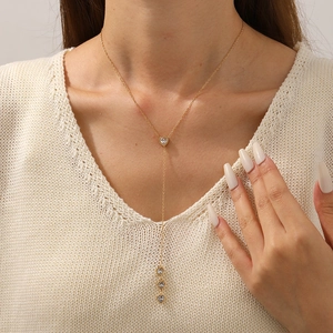 Elegant gold Y-shaped stainless steel necklace featuring crystal heart pendants on model