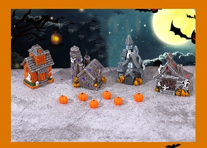 Macro view of miniature Halloween resin haunted houses and orange pumpkins decor