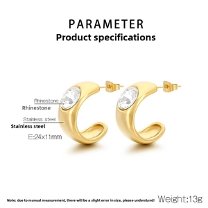 Detail of gold C-shaped stainless steel earrings featuring a large oval crystal inlay
