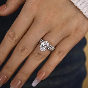 Detail eines eleganten Ringsets mit ovalem Hauptstein und Pavé-Diamanten am Modell
