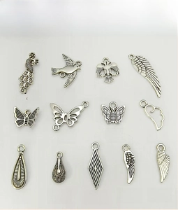 Detailansicht von dreizehn antiken Schmetterlings- und Flügelanhängern aus Silber für DIY-Schmuck