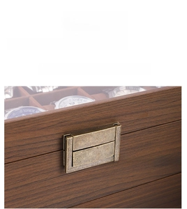 Detail of walnut wood watch box featuring a vintage bronze lock and clear display window