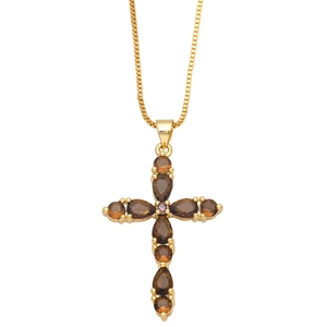 Detail shot of golden cross pendant featuring brown pear-shaped zircon gemstones