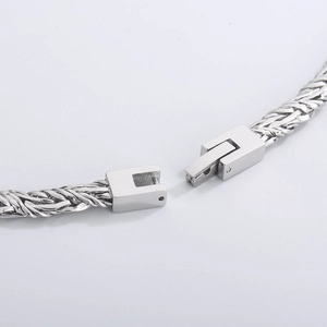 Macro shot of silver titanium steel woven chain showing the open lobster clasp detail