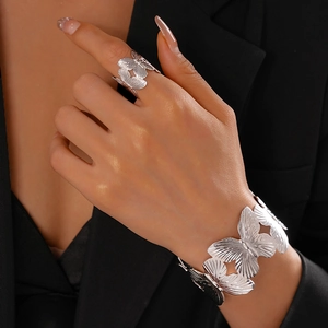 Detail of silver butterfly cuff bracelet and ring set with textured metallic finish
