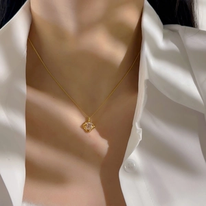 Elegant gold chain necklace with a square cubic zirconia pendant worn by a model