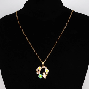 Détail d'un collier doré avec une couronne de fleurs colorées et pendentif lapin rose