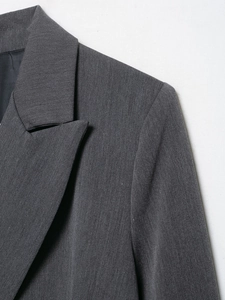 Gros plan de l'épaule et du revers cranté d'un blazer gris anthracite en sergé