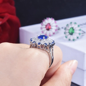 Close-up of sapphire blue halo ring with vintage radiant petal design and silver band