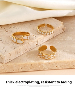 Detailed view of three gold heart and geometric adjustable rings on travertine stone