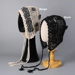 Detailed close-up of handmade crochet flower bandanas in beige and black with tassels