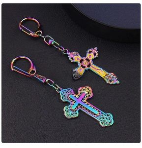Detailed macro view of two iridescent rainbow alloy cross keychains on black background