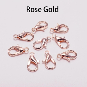 Set of eight polished rose gold lobster clasps for jewelry making on white background