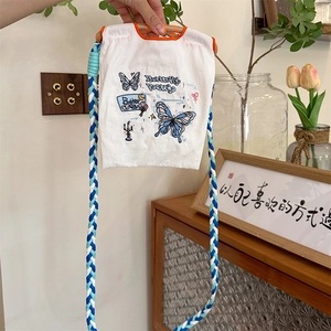 Détail de la broderie papillon sur un mini sac bandoulière en tissu oxford avec sangle